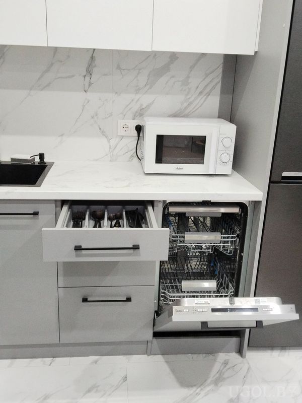 Рабочая зона с микроволновкой «Haier», открытым ящиком с приборами и встроенной посудомоечной машиной.
