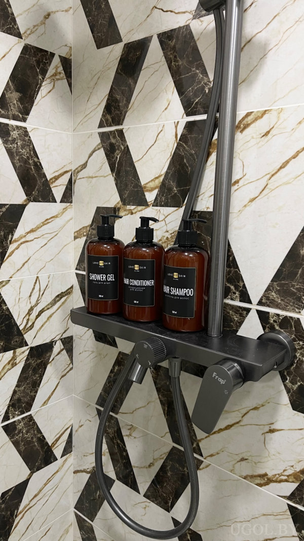 Три флакона «LOVE MY SKIN» для душа, кондиционера и шампуня на фоне геометрической плитки, смеситель «Frap».