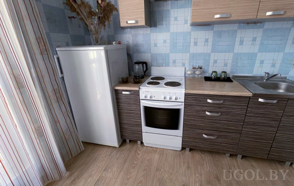 Рабочая зона с плитой, раковиной, кофеваркой и настенными шкафами, оформленная в голубых тонах и светлом дереве.