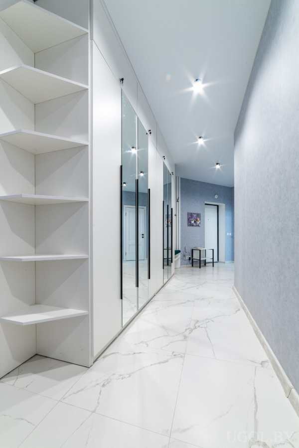 Белая мебель, серые стены, мраморный пол и картина в конце коридора подчёркивают современный стиль.