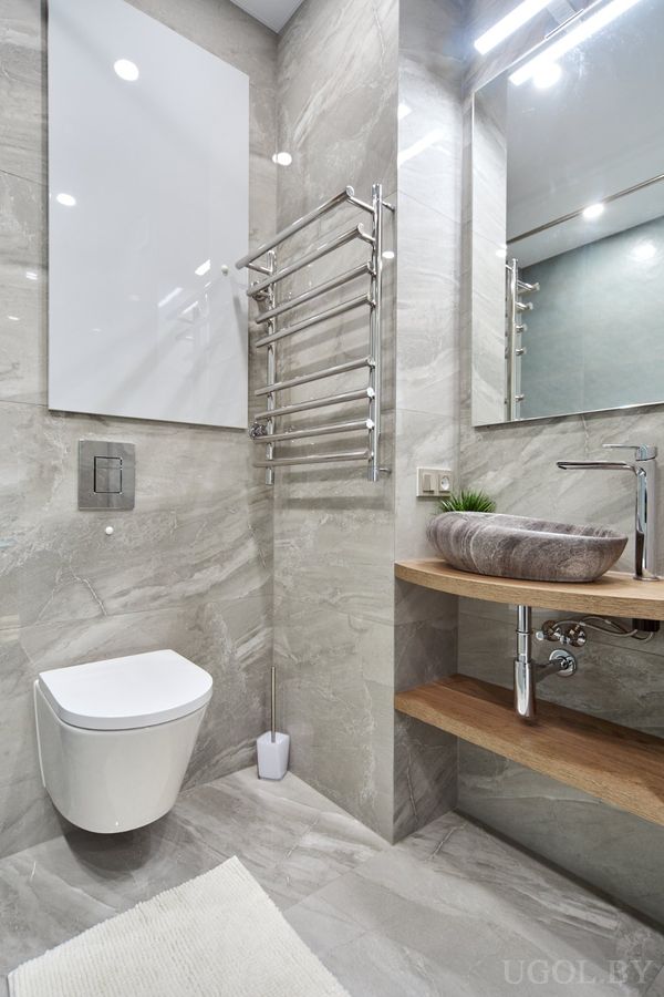 Современная ванная с серой плиткой, деревянной столешницей, круглой раковиной и зеркалом с подсветкой.