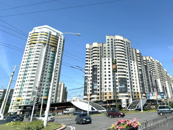 Уличная сцена с McDonald's, KFC, машинами, цветниками и современными жилыми домами.