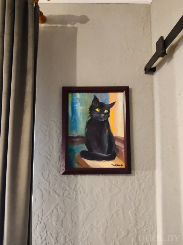 Фрагмент интерьера с яркой картиной, изображающей чёрного кота с жёлтыми глазами на фоне цветных мазков, автор — «T. MASANDI».