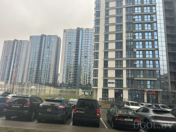 Высотные дома с коммерческими помещениями, парковка, спортивная площадка и надпись «САЛОН КРАСОТЫ» на фасаде.