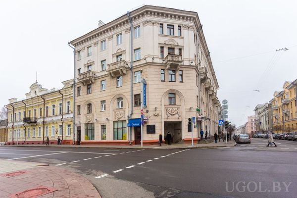 Городской перекрёсток с классическим зданием, вывесками Priorbank и Western Union на первом этаже.