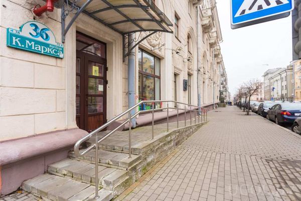 Фасад здания с адресной табличкой «ул. К. Маркса, 36», пандусом и лестницей с перилами.