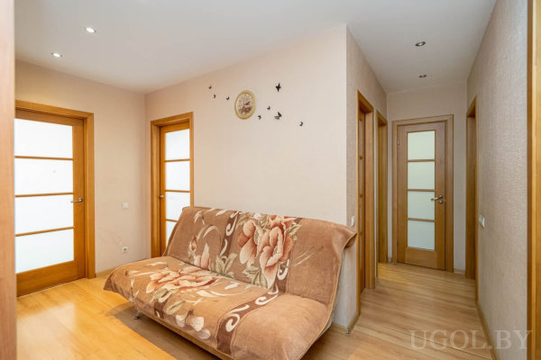 Флоральный диван, четыре двери, настенные птицы, часы и светлый ламинат с точечным освещением.