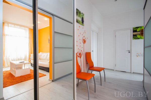 Коридор со стульями, наклейками цветов и шкафом‑купе с матовыми раздвижными дверями, ведущий в гостиную.
