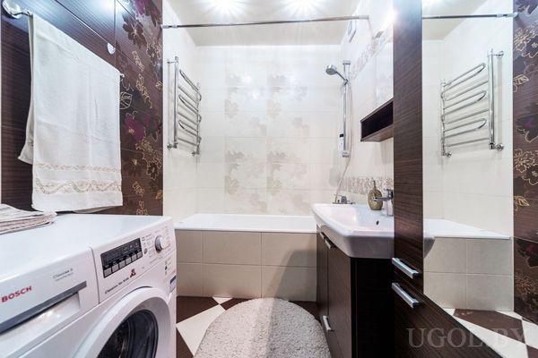 Интерьер с ванной, умывальником, стиральной машиной Bosch и двумя полотенцесушителями.