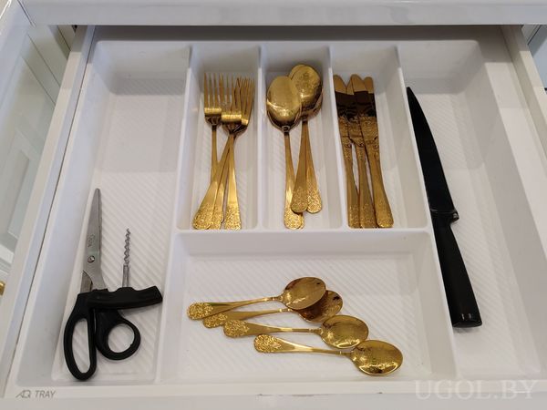 Открытый ящик с ложками, вилками и ножами в золотом оформлении, ножом, штопором и ножницами.