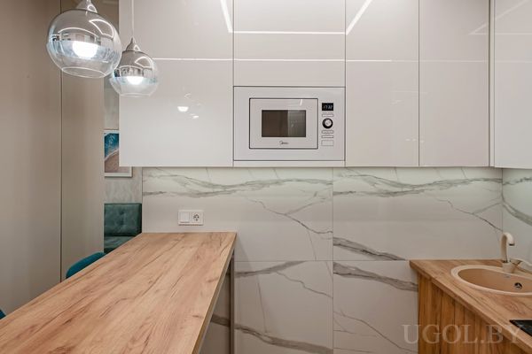 Современная кухня с деревянной столешницей и мраморным фартуком