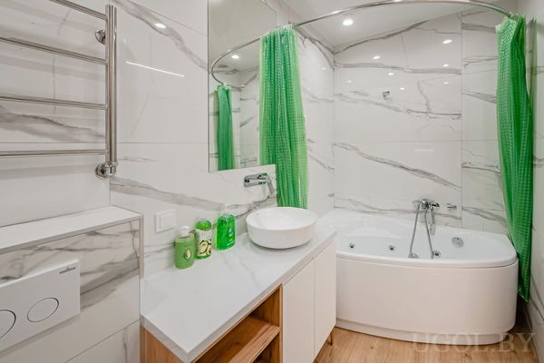 Ванная комната с угловой ванной, умывальником и зелёной шторой