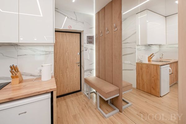 Прихожая с кухонной зоной, встроенной вешалкой и мягким сиденьем