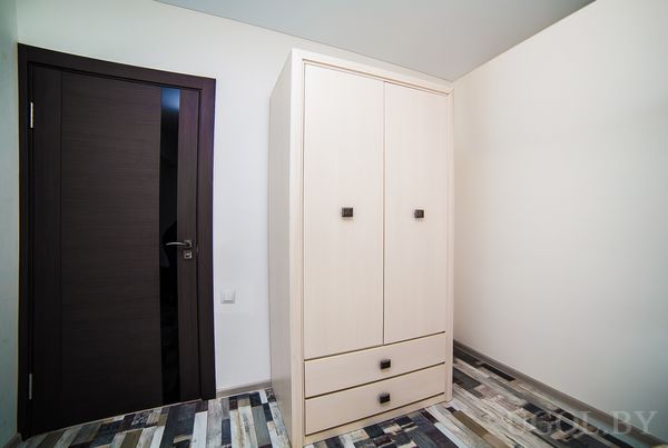 Интерьер с дверью, шкафом, плиткой с узором и белыми стенами.