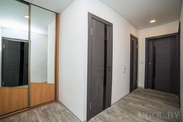 Зона прохода с дверями, шкафом, плиткой и точечным освещением.