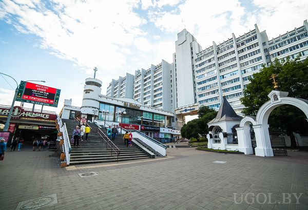 Городская сцена с лестницей, часовней, аркой, людьми и вывесками на фоне.