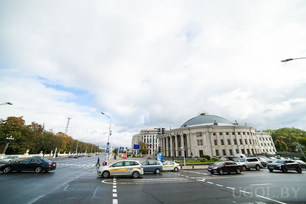Оживлённый перекрёсток с машинами и зданием цирка с куполом и колоннами на фоне современных построек.