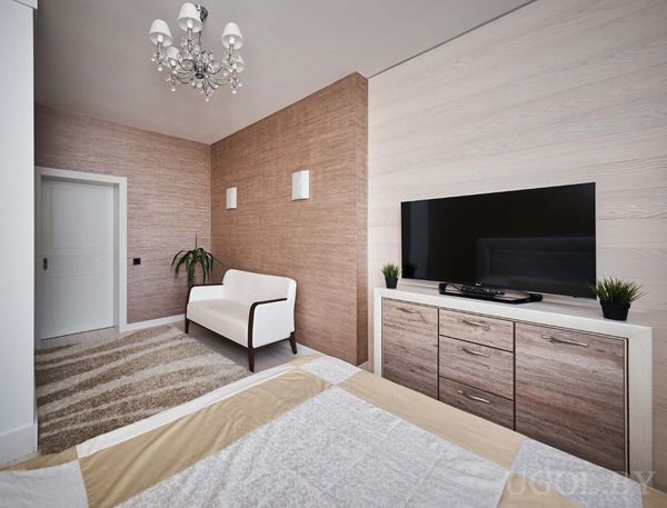 Плазма на комоде, белый диван у коричневой стены, люстра и ковёр в полоску создают гармонию.