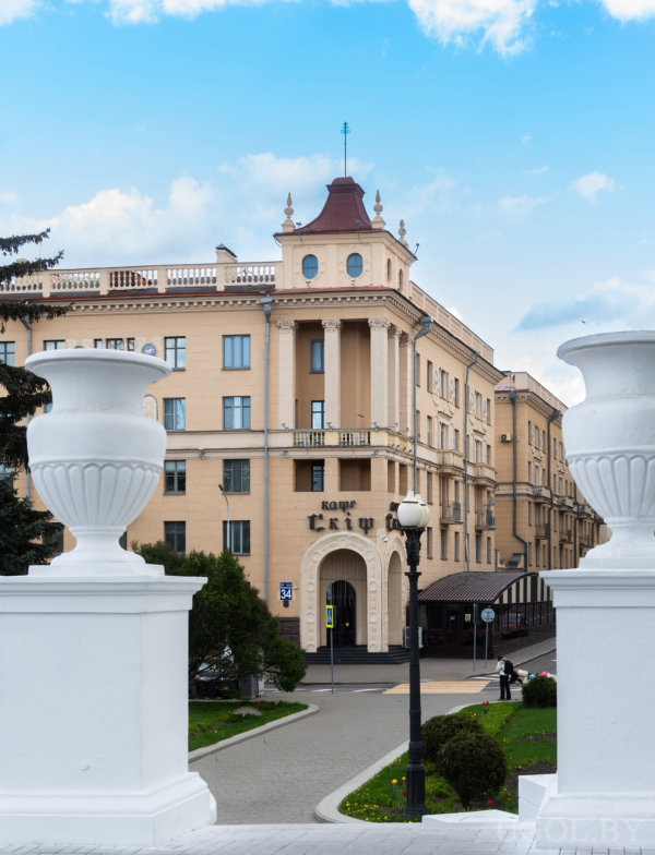 Арочный вход с вывеской «кафе Скіф», декоративные вазы, колонны и номер дома «34» в классическом окружении.