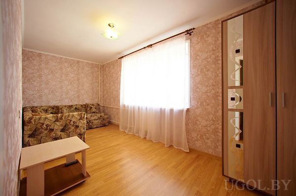 Угловой диван, шкаф с геометрией, столик с полкой, светлая отделка, акцент на порядок и функциональность.