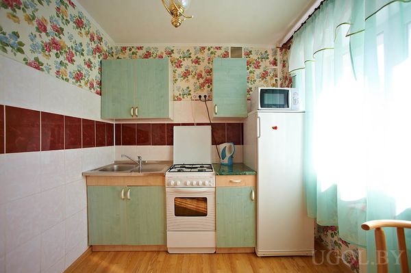 Маленькая, но удобная кухня, холодильник с микроволновкой, плитка в бордовых тонах, тюль, вся техника на месте.