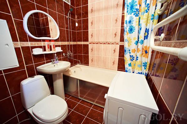 Комбинированная плитка, ванна с экраном, зеркало с полкой, машинка рядом, компактно и удобно, яркая штора.