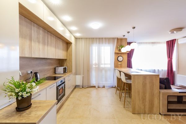 Барная стойка с белыми стульями и подвесным светом в кухонной зоне