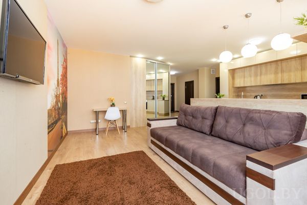 Просторная студия с угловым диваном, рабочим местом и настенной фотопанелью