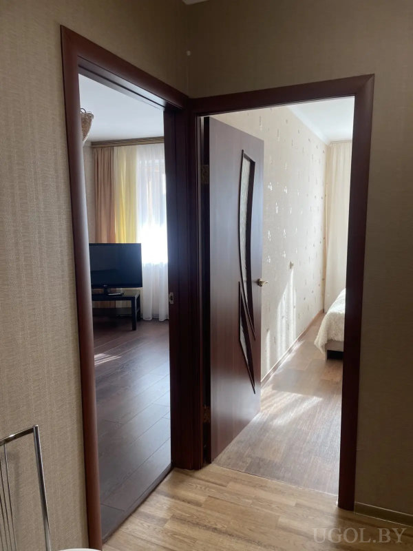 Маленькая лоджия с деревянной обшивкой, ковриком с геометрическим узором и плетеной корзиной.