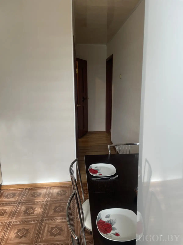 Компактная ванная с белой раковиной, зеркальным шкафом и ванной с зелеными панелями.