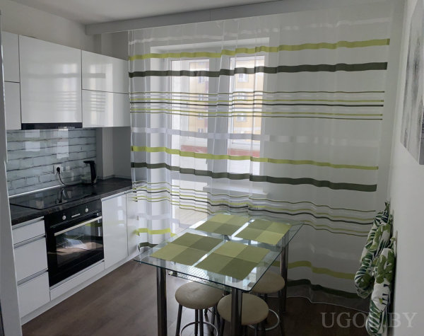 Интерьер с плитой, чайником, столом, табуретами, тюлем и полосатыми шторами.
