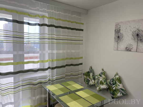 Композиция с подушками, столом, салфетками, тюлем, шторами и настенным декором.