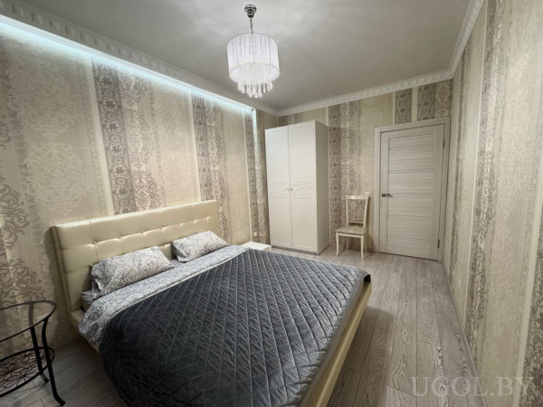 Комната с кроватью, подушками, шкафом, креслом, люстрой, тюлем и светодиодной подсветкой.