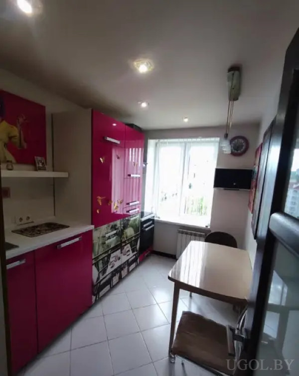 Яркая кухня с фотопринтами, бабочками и небольшой обеденной зоной у окна с видом на город.