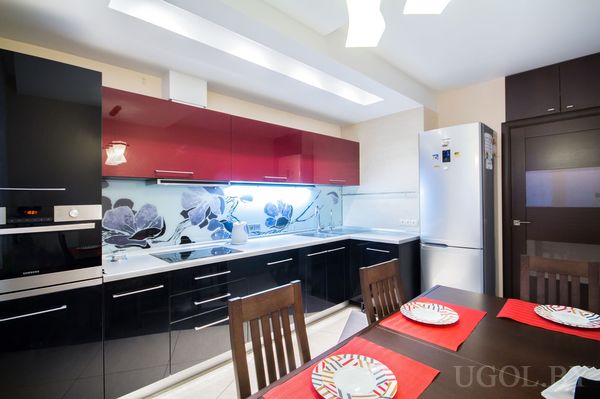 Интерьер с плитой, вытяжкой, столом, холодильником, сервировкой и декоративным фартуком.