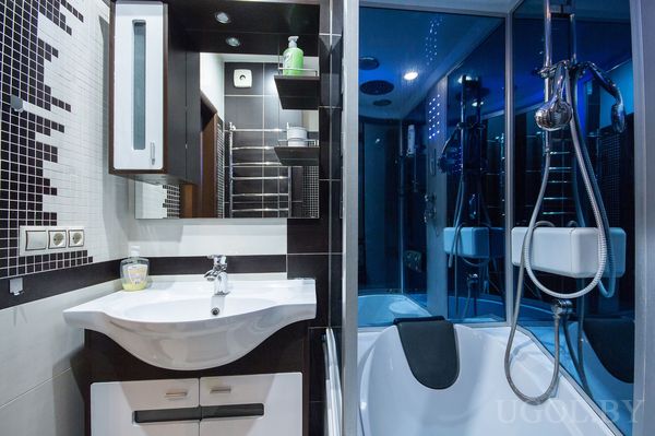 Интерьер с ванной, душем, умывальником, зеркалом, полками и декоративной плиткой.