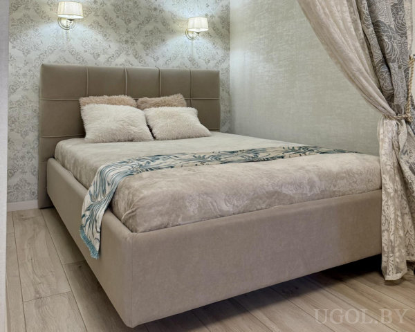 Кровать с бежевым изголовьем, светлое покрывало, подушки в бело-бежевых тонах и декоративная дорожка с синим узором.