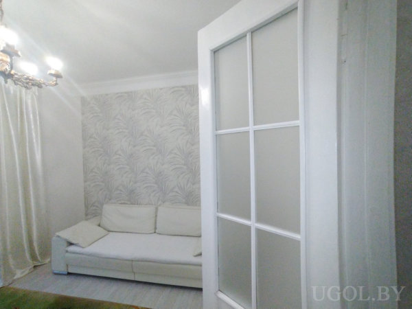 Композиция с диваном, открытой дверью, люстрой, тюлем и светлым напольным покрытием.