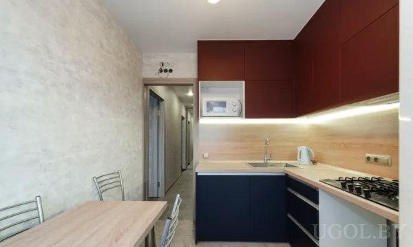 Современный интерьер с деревянным столом, встроенной техникой и светлой отделкой.