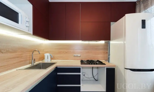 Минималистичный дизайн с белой столешницей, открытым ящиком и встроенной техникой.