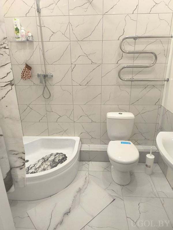 Светлая ванная с душевой кабиной, унитазом, ванной и настенным полотенцесушителем.