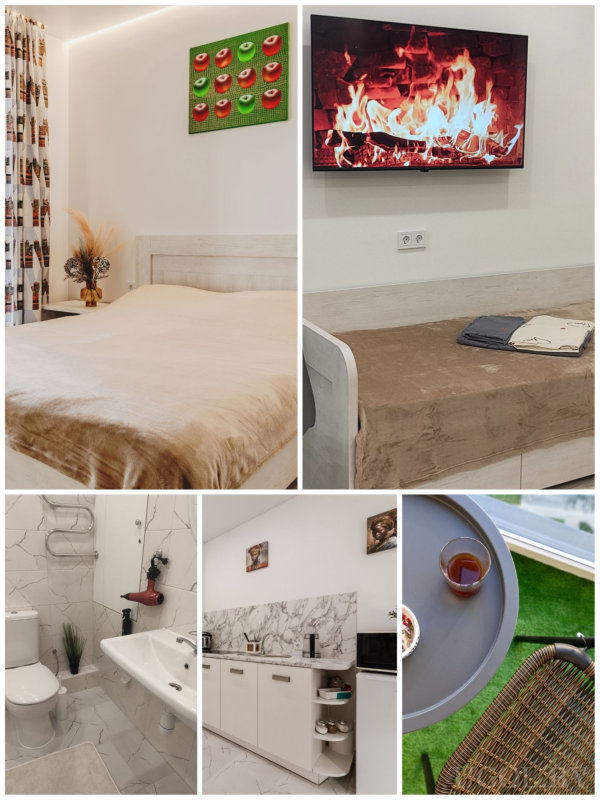 Спальня с бежевым покрывалом и картиной, уютная гостиная с телевизором и камином на экране, ванная с мраморной плиткой и красным феном, кухня с белыми шкафами и мраморным фартуком, балкон с столиком и искусственной травой.