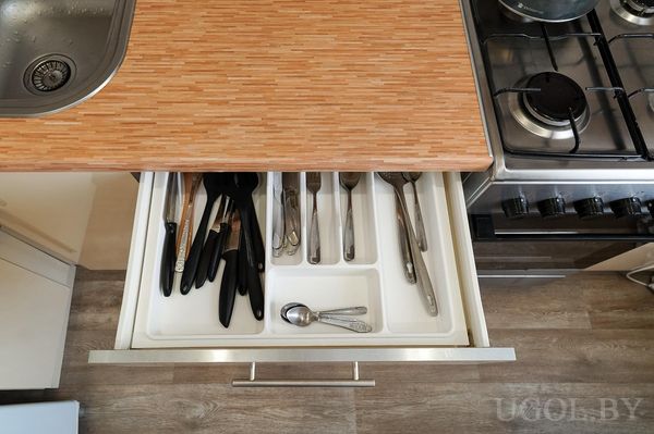 Открытый ящик с органайзером, столовыми приборами, лопатками и кухонными аксессуарами.