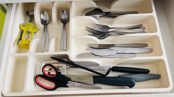Лоток с ложками, вилками, ножами, штопором, тёркой, ножом и ножницами.