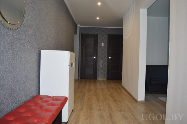 Два тёмных дверных полотна, декоративное зеркало и банкетка на фоне тёмных обоев.